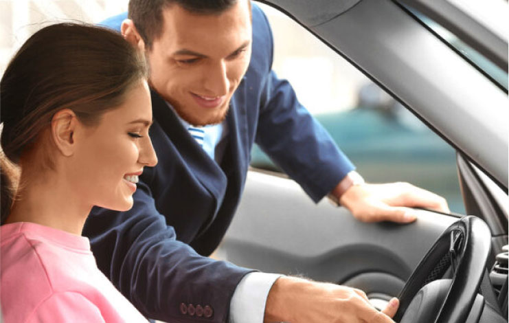 Image of salesperson showcasing vehicle features to a customer.