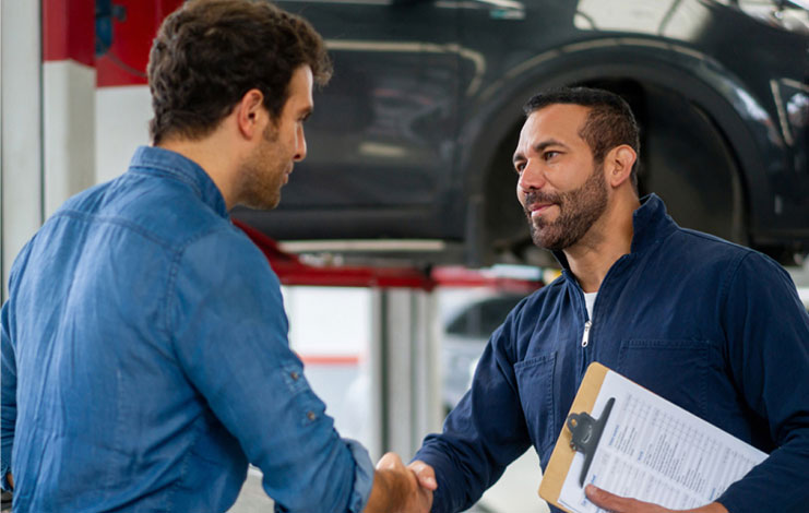 Image of a service technician shaking hands with a customer.