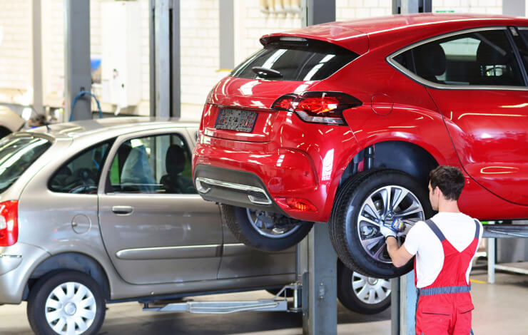 Image of mechanic working on cars in garage