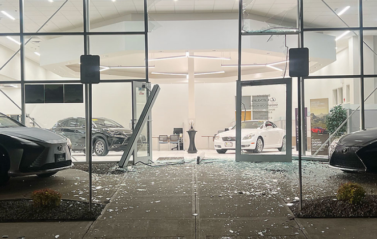 Broken glass and damaged door of a car dealership caused by a break-in