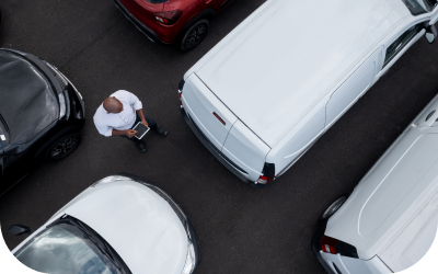 Image of an Account Executive looking at a tablet in a car lot.